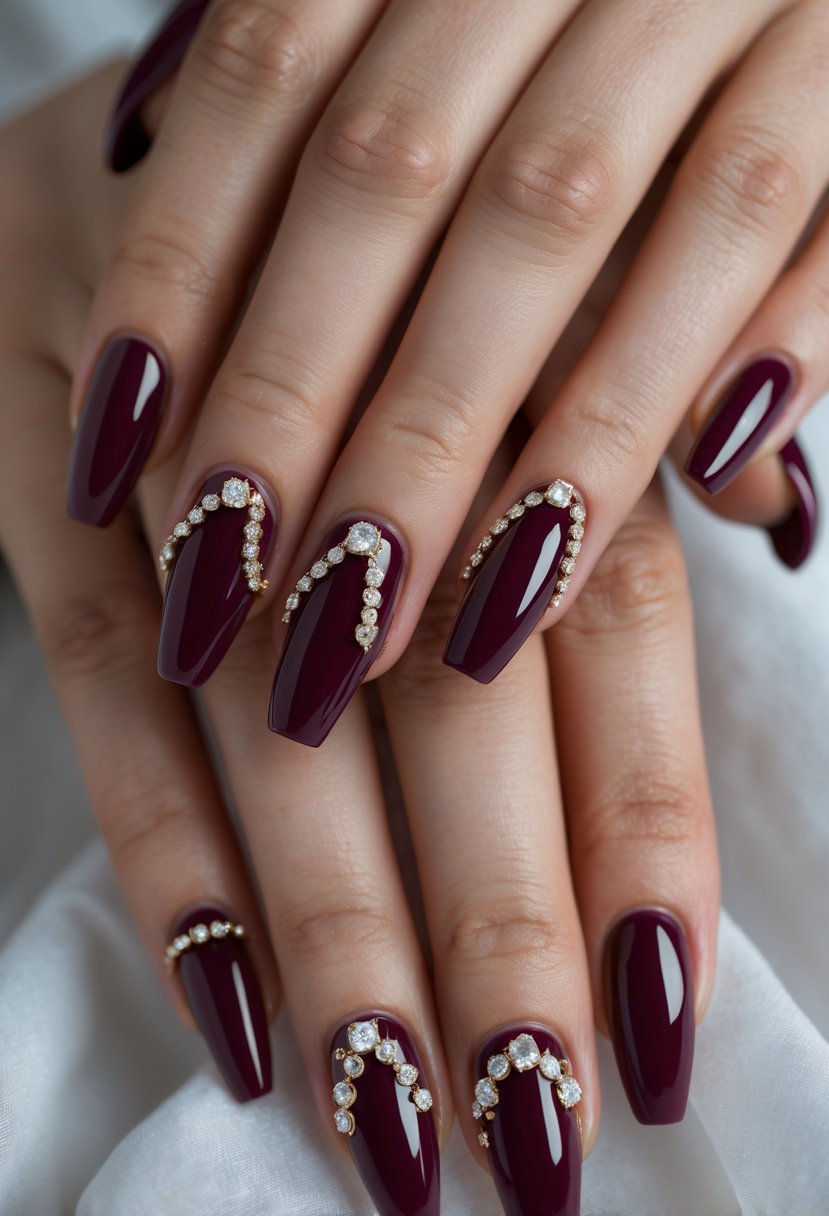 Close-up of hands with eight burgundy nails decorated with jewel embellishments.
