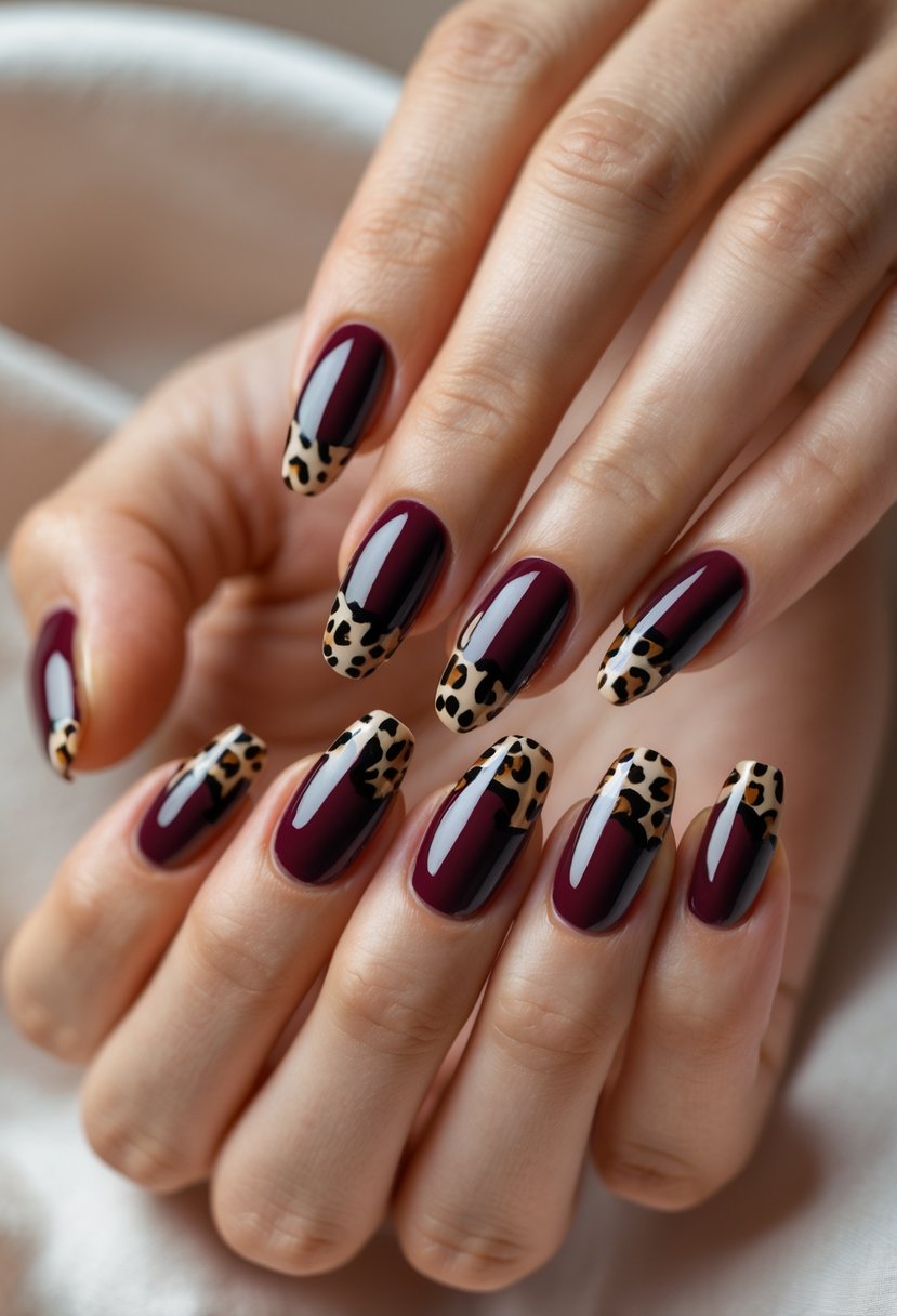 Close-up of hands with maroon nails featuring leopard print tips.