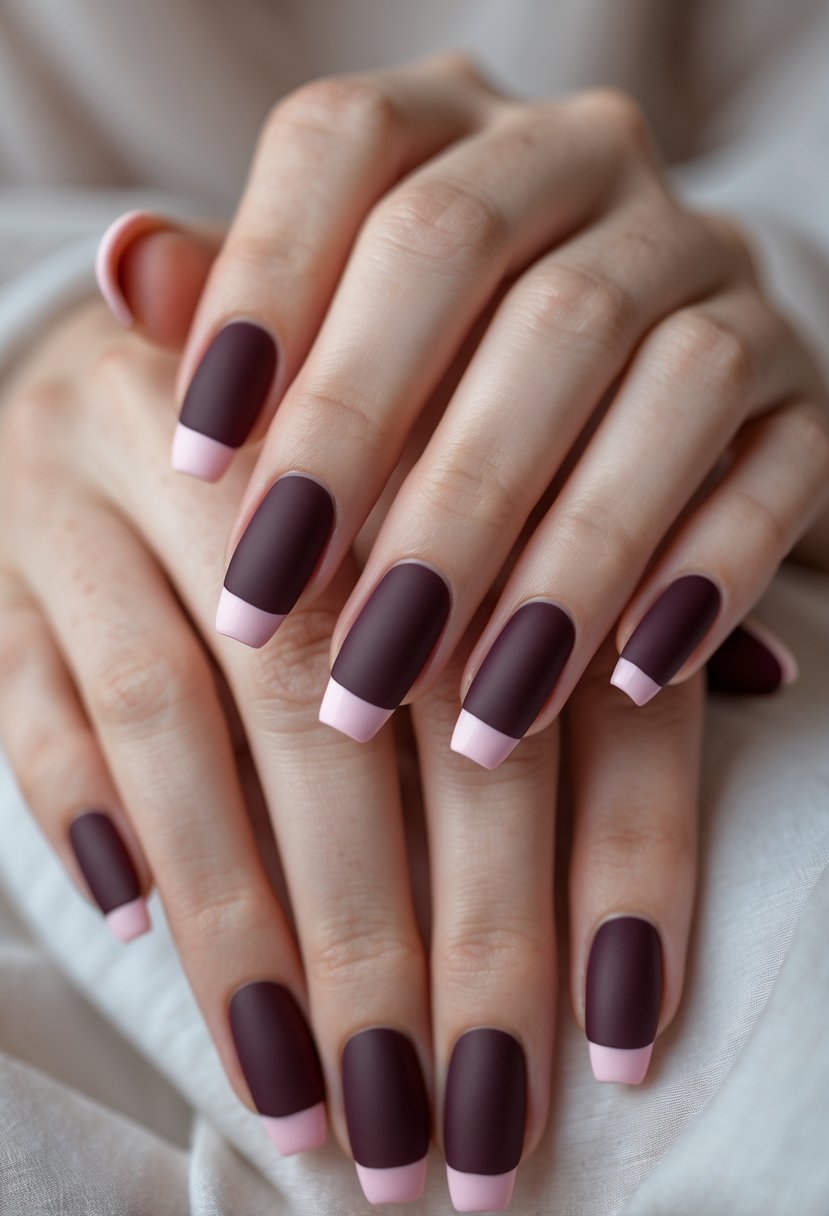 Close-up of hands with maroon matte nails and light pink tips.